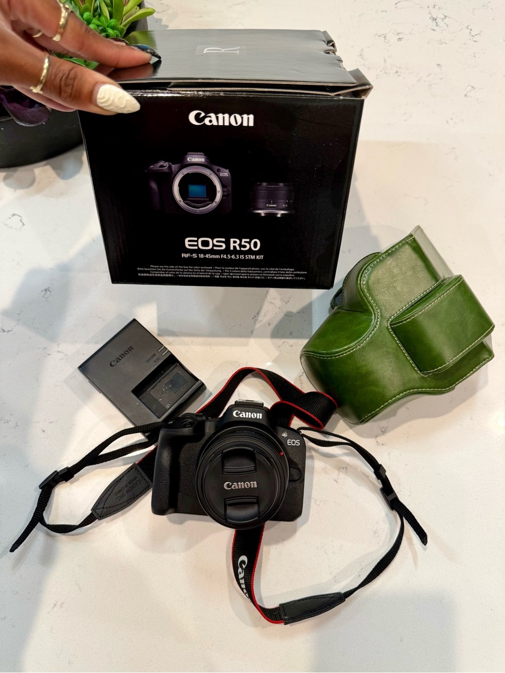 Canon EOS R50 Black Mirrorless Camera with Red-Trim Strap and Green Case
